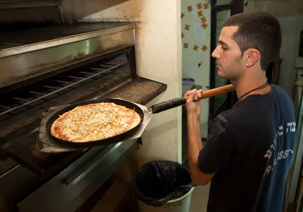 הפיצאיולו מכניס מגש לתנור